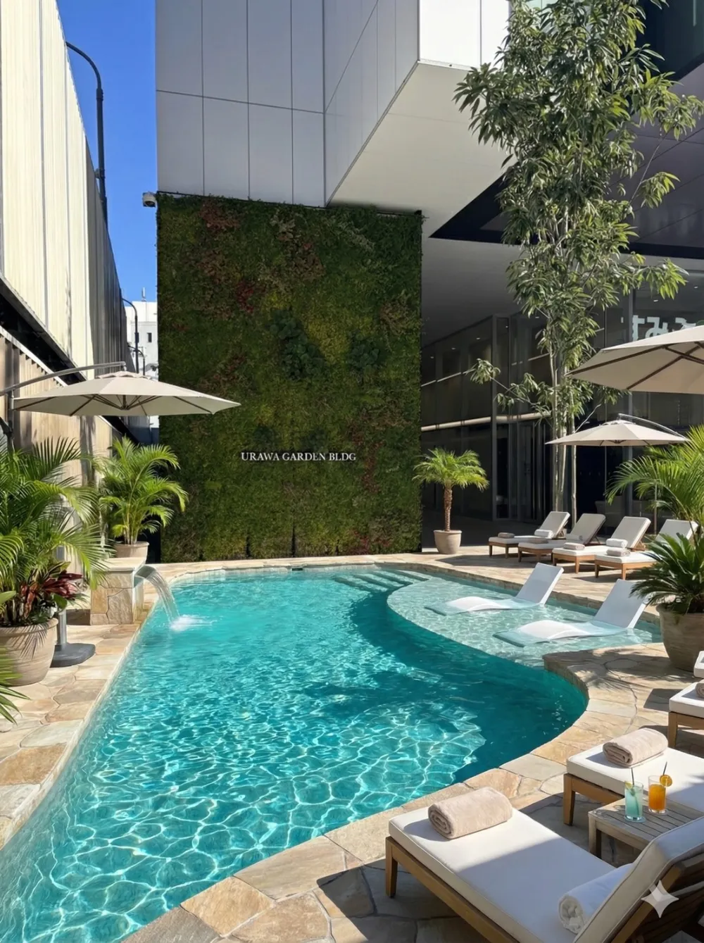 緑豊かな壁面と曲線美のプールが調和するラグジュアリーな屋外空間