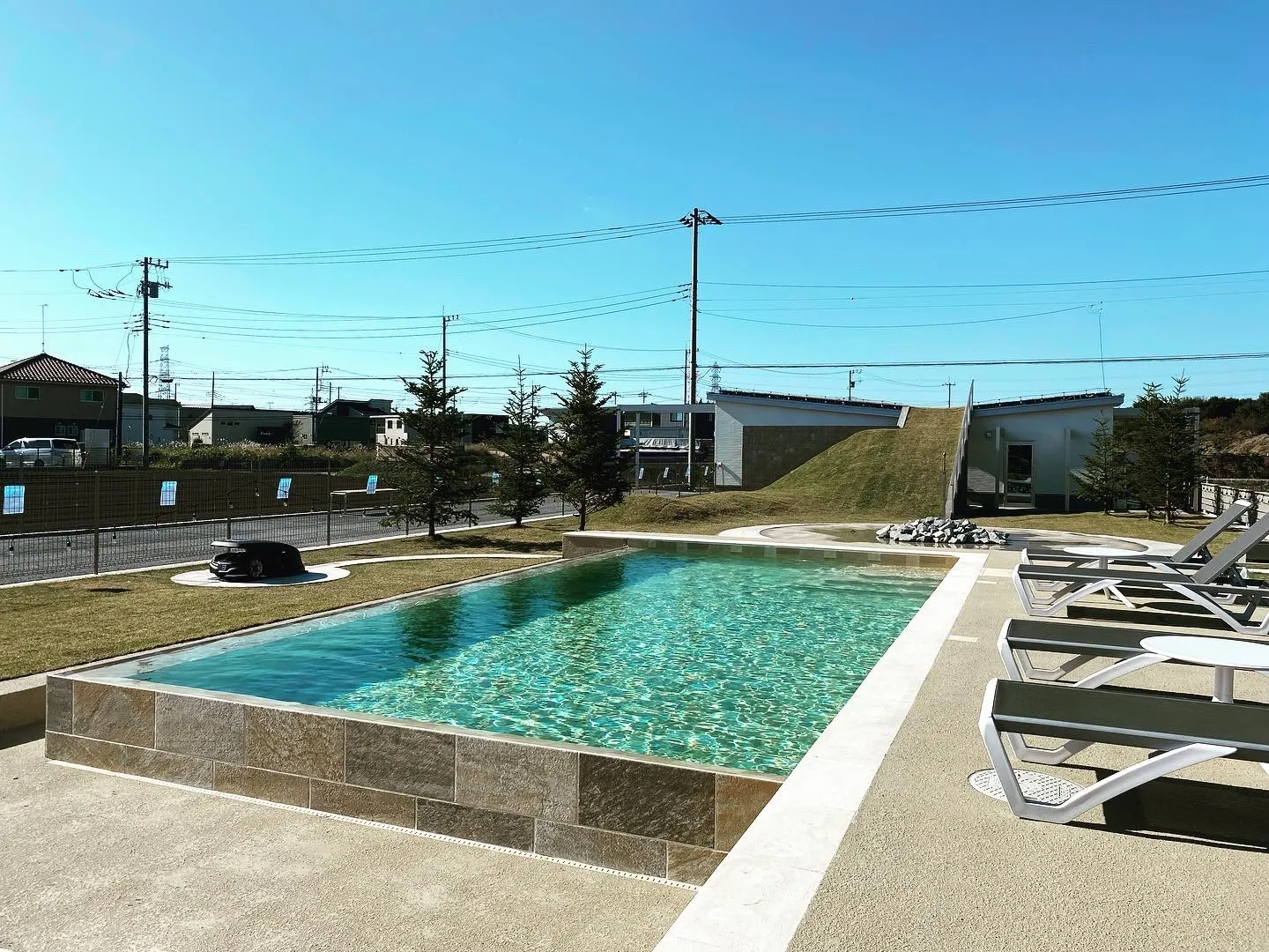 未来庭苑つくばの屋外プールとプールサイドのラウンジチェア